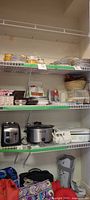Shelf view showing toaster, slow cooker, hand mixer and other kitchen items