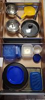 Drawer overview showing pots, pan, colander, utensils, storage containers, bakeware and plates