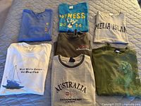 Overview of seven vintage T-shirts laid out on bed