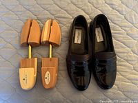 Loafers and shoe trees side by side on quilted surface