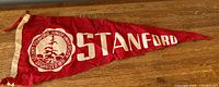 Full view of red Stanford felt pennant on wood surface