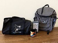 Overall view showing duffel, backpack, sign, mug