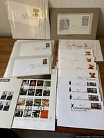 Group view of assortment of U.S. Postal Service first day covers, commemorative stamp panes, souvenir sheets arranged on table