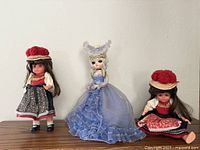 Full group view of three dolls on shelf