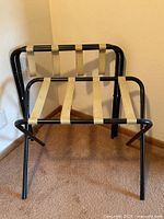 Both folding luggage racks fully opened showing black metal frames and beige straps