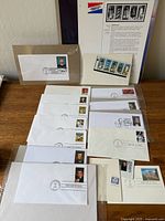 Group view of all first day covers, souvenir sheet and envelopes on table