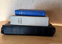 Three Bibles stacked, showing spines