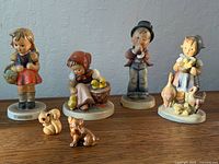 Front view of four Hummel child figurines and two small animal figures