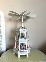 Full view of three-tier wooden Easter pyramid carousel on table