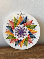 Front of round plaque showing colourful mandala design and Costa Rica marking
