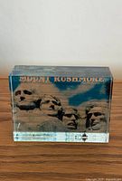 Front view of clear acrylic paperweight with Mount Rushmore image and gold text