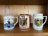 Front view of all three ceramic mugs on shelf