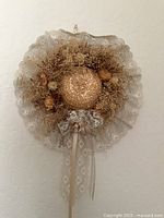 Front view of small wicker and dried flower wreath with lace backing and ribbon