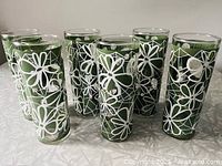 All six avocado green tumblers with white floral pattern front view