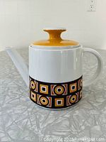 Full view of teapot showing body, spout, handle and patterned band