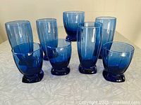 Full set of eight cobalt blue glasses on table