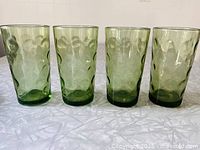 Front view of four green Optic Dot glasses standing in a row