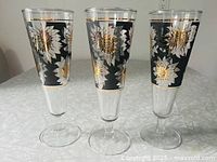 Front view of three pilsner glasses showing full pattern
