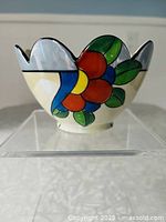 Front view showing scalloped rim and floral motif