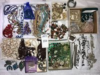 Overview of entire jewelry lot showing variety of necklaces, pearls, mesh purse, brooches and beads