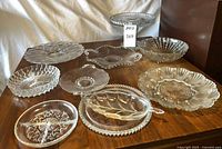 Group shot of all ten clear glass serving pieces on table