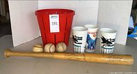 Full lot showing bat, three baseballs, three cups, red basket
