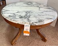 Full view of round coffee table showing marble top and wood base