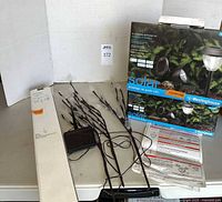 Solar leaf stake lights, external solar panel, and boxed Westinghouse solar LED landscape lighting on table