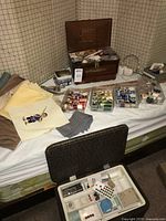 Overview of lot on bed showing trays of thread, fabric pieces, organizers and yardsticks