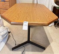 Full view of table with leaf installed, metal pedestal base visible