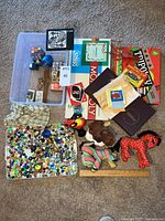 Overview of lot showing board games, marbles, plush toys, music box, wooden blocks and ruler