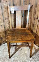 Front view of antique Mission style wooden dining chair on carpet