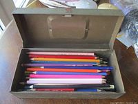 Open metal box showing coloured pencils inside