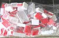 Bag filled with assorted white/red plastic boxes