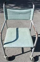 Front view of metal chair showing seat, backrest and casters