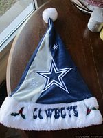 Full view of Dallas Cowboys plush Santa hat showing overall design and pom-pom