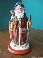 Front view of Father Christmas figurine showing animals, walking stick, and base