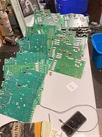 Stack of green circuit boards spread on table