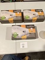 Three boxed thermostat covers on table