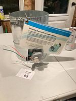 Full view of damper showing cylindrical body, actuator, wires and info card