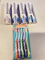 Four Sensodyne toothpaste boxes and toothbrush pack overview