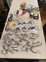 overview of all bagged cables, hard drives, patch cords, test leads and connectors on table