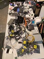 Table view of assorted routers, cables, boxed modules, circuit boards