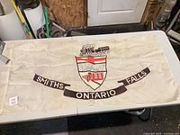 Full view of white flag with crest and scroll text
