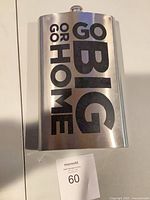 Front view of oversized stainless steel flask showing slogan