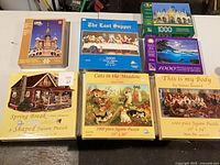 Overview of seven sealed jigsaw puzzles on table