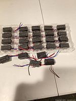 Tray containing multiple identical RECOM RAC20-48SK/W modules with wire leads