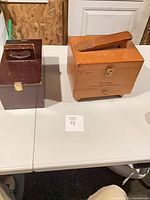 Two shoe shine boxes on table