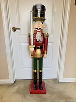 Full view of wooden nutcracker on red base
