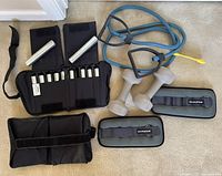 Group view showing Keiser adjustable ankle-weight cuffs, removable bars, BalanceFrom ankle-weight cuffs, two 8-lb grey dumbbells, blue resistance band